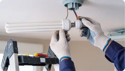 An electrician fitting a ceiling light in a Bournemouth home